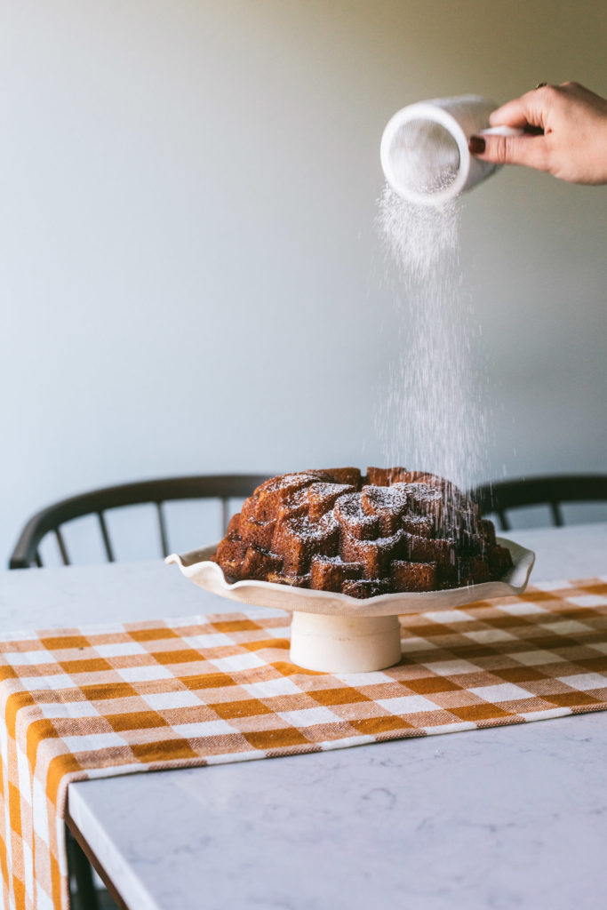 Powdered sugar dusting onto Salted Caramel Bundt Cake