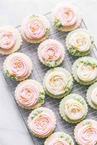 cookies on a cooling rack decorated with american buttercream frosting